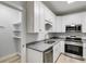 White cabinets with granite counters and stainless appliances in a modern kitchen at 410 N Carroll N St, Bowdon, GA 30108