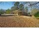 Large backyard with mature trees and a covered patio at 8586 Taylor Rd, Riverdale, GA 30274