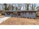 Charming single-story home with gray painted brick, brown shutters, and mature trees at 2725 Shoreland Sw Dr, Atlanta, GA 30331