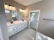 Primary bathroom with dual sinks, tile floors, framed mirror and a view into the main bedroom at 44 Easton Park Blvd, Dallas, GA 30157