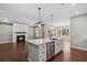 Open-concept kitchen features an island, stainless steel appliances, and a view of the living room at 44 Easton Park Blvd, Dallas, GA 30157