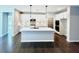 Bright kitchen features white cabinets, stainless steel appliances, a center island, and gorgeous wood floors at 44 Easton Park Blvd, Dallas, GA 30157