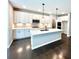 Bright kitchen features white cabinets, stainless steel appliances, a center island, and gorgeous wood floors at 44 Easton Park Blvd, Dallas, GA 30157