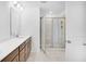 Bright bathroom featuring double sinks, wood cabinets, tile floors, and a glass door shower at 3812 Thatcher Sw Dr, Marietta, GA 30008