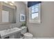 Clean bathroom boasts a pedestal sink, framed mirror, soft paint and a window at 3812 Thatcher Sw Dr, Marietta, GA 30008