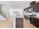 Open-concept kitchen boasts granite countertops, stainless steel appliances, and sleek dark cabinetry at 3812 Thatcher Sw Dr, Marietta, GA 30008
