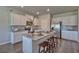 Kitchen island with granite counters, seating, white cabinets, stainless appliances, and hardwood floors at 5424 Flat Rock Point, Stonecrest, GA 30038