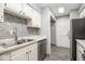 Updated kitchen features white cabinets, stainless steel appliances, and tile backsplash at 113 Rue Fontaine # 113, Lithonia, GA 30038