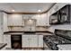 Updated basement kitchen, featuring black appliances and white cabinets at 208 Hickory Rdg, Cumming, GA 30040