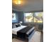 A stylish bedroom features a tufted headboard, plush bedding, soft rug and large window with city views at 2479 Peachtree Ne Rd # 1103, Atlanta, GA 30305