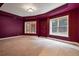 Finished basement room with carpeting and burgundy walls, featuring two large windows at 745 Glengate Pl, Atlanta, GA 30328