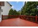 Large red deck with wooden railings, offering a peaceful backyard view at 745 Glengate Pl, Atlanta, GA 30328