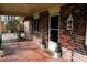 Brick front porch with tiled floor, white door, and potted plants at 2499 Little John Se Trl, Marietta, GA 30067
