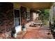 Brick front porch with tiled floor, metal bench, and storm door at 2499 Little John Se Trl, Marietta, GA 30067