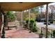 Spacious covered porch with red tile floor and view of the street at 2499 Little John Se Trl, Marietta, GA 30067