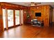 Living room with wood paneling, hardwood floors, and deck access at 2499 Little John Se Trl, Marietta, GA 30067