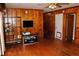 Living room with wood walls, hardwood floors, and built-in shelving at 2499 Little John Se Trl, Marietta, GA 30067