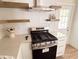 Modern kitchen with floating shelves, gas range, and stainless steel appliances at 1912 Canmont Ne Dr, Atlanta, GA 30319