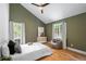 Cozy bedroom featuring wood floors, green walls, and a comfy chair at 510 Watergate Ct, Roswell, GA 30076