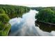 Aerial view of a serene lake surrounded by lush greenery at 510 Watergate Ct, Roswell, GA 30076