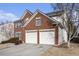 Brick home with a two-car garage and mature trees at 126 Towey Trl, Woodstock, GA 30188