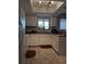 Galley kitchen with white cabinets, tile floors, and skylight at 21 Muncy Se Ct, Smyrna, GA 30080