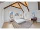 This bedroom features high ceilings, wood beams, an accent rug, and a sitting area with a stylish leather chair at 731 Belt Se Loop, Atlanta, GA 30316