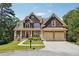 Two-story house with a brown shingle exterior, beige accents, and a three-car garage at 15 Amberly Ln, Cartersville, GA 30121