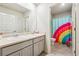 Bathroom with double sinks and rainbow shower curtain at 3811 River Rock Rd, Lithonia, GA 30038