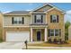 Two-story brick home with a large front yard and attached garage at 3811 River Rock Rd, Lithonia, GA 30038