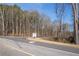 Roadside view of community sign and available homesites surrounded by mature trees at 181 Woodfin Way, Social Circle, GA 30025