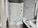 Bathroom featuring a white shower stall, toilet, sink and mirror at 860 Flat Shoals Rd, Atlanta, GA 30349