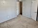 Bedroom featuring neutral gray walls, tan carpet, and a doorway to another room at 860 Flat Shoals Rd, Atlanta, GA 30349