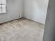 Neutral colored bedroom with gray walls, tan carpet, a window, and white baseboards at 860 Flat Shoals Rd, Atlanta, GA 30349