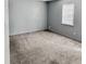 Neutral colored bedroom with gray walls, tan carpet, and a window providing natural light at 860 Flat Shoals Rd, Atlanta, GA 30349