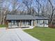 Newly constructed home with gray siding, a covered porch, and a landscaped lawn at 445 Milton Dr, Canton, GA 30114