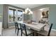 Bright dining room with large window, modern chandelier, and a concrete-topped table with stylish chairs at 1346 Auburn Glen Rd, Dacula, GA 30019