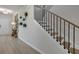 Hallway view of wood stairs with black metal railing, neutral walls, and decorative wall planters at 1346 Auburn Glen Rd, Dacula, GA 30019