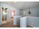 Upstairs hall with carpet, doors to bedrooms and bathroom, and half wall at 230 Bennett Farms Trl, Acworth, GA 30102