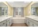 Bright bathroom with double vanity, soaking tub with tile surround and neutral paint at 515 Lees Sw Trce, Marietta, GA 30064