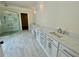 Spa-like primary bathroom with double vanities, marble floors, and a glass-enclosed shower at 4412 Brookview Se Dr, Atlanta, GA 30339