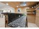 Close up of finished basement bar, showing granite countertops, shelving and wood paneling at 5025 Hidden Ct, Cumming, GA 30040