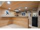 Basement bar area featuring wood paneling, granite counters, shelves, and a mini refrigerator at 5025 Hidden Ct, Cumming, GA 30040