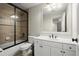 Bathroom featuring a white vanity, toilet, and tiled shower-tub with sliding glass door at 5025 Hidden Ct, Cumming, GA 30040