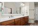Bright bathroom with dual sinks, cherry cabinets, a large mirror, and a separate shower at 5025 Hidden Ct, Cumming, GA 30040