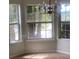 Bay windows illuminate this carpeted dining room complemented by an elegant chandelier at 2080 Winding Crossing Trl, Fairburn, GA 30213