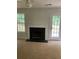 Bright living room with fireplace, ceiling fan, and large window for ample natural light at 2080 Winding Crossing Trl, Fairburn, GA 30213