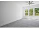 An empty bedroom featuring carpet, a ceiling fan and large windows at 6745 Dahlgren Ct, Cumming, GA 30028