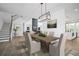 Bright dining room features a modern light fixture, and is open to the kitchen, living room, and staircase at 6745 Dahlgren Ct, Cumming, GA 30028