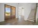 Bright entryway featuring hardwood floors, a staircase, and large glass double doors at 6745 Dahlgren Ct, Cumming, GA 30028